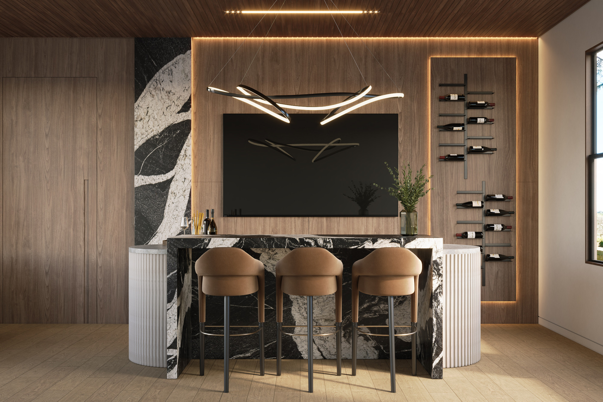 Frontal view of a home bar with a black and white marble counter, fluted stone bases, walnut paneled wall, black metal wall wine racks, wall-mounted television, sculptural linear pendant and tan leather bar stools.