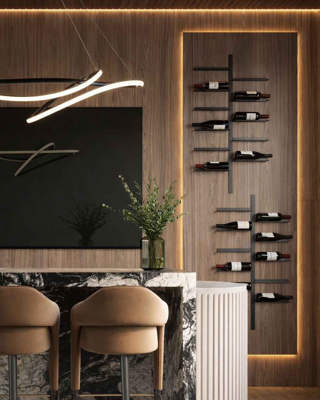 Home bar detail with a black and white marble waterfall counter, tan leather bar stools with brass footrests, a walnut wall with a backlit recessed wine display, and a fluted plaster pedestal.